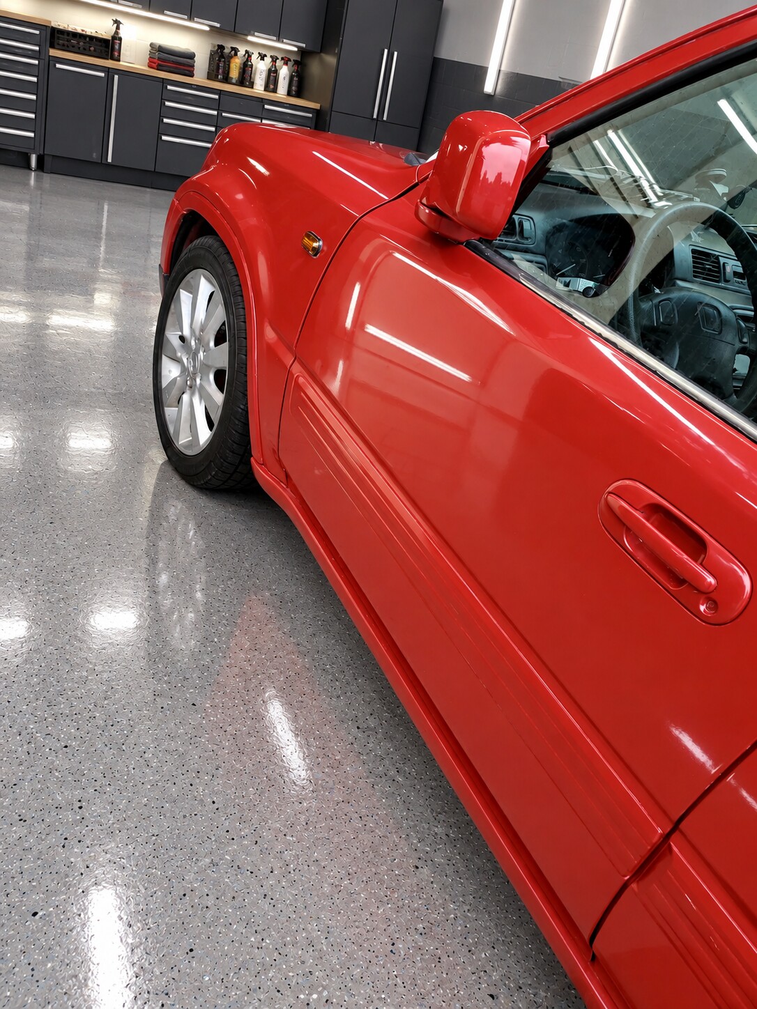 Close-up detail of the finished glossy red automotive paint